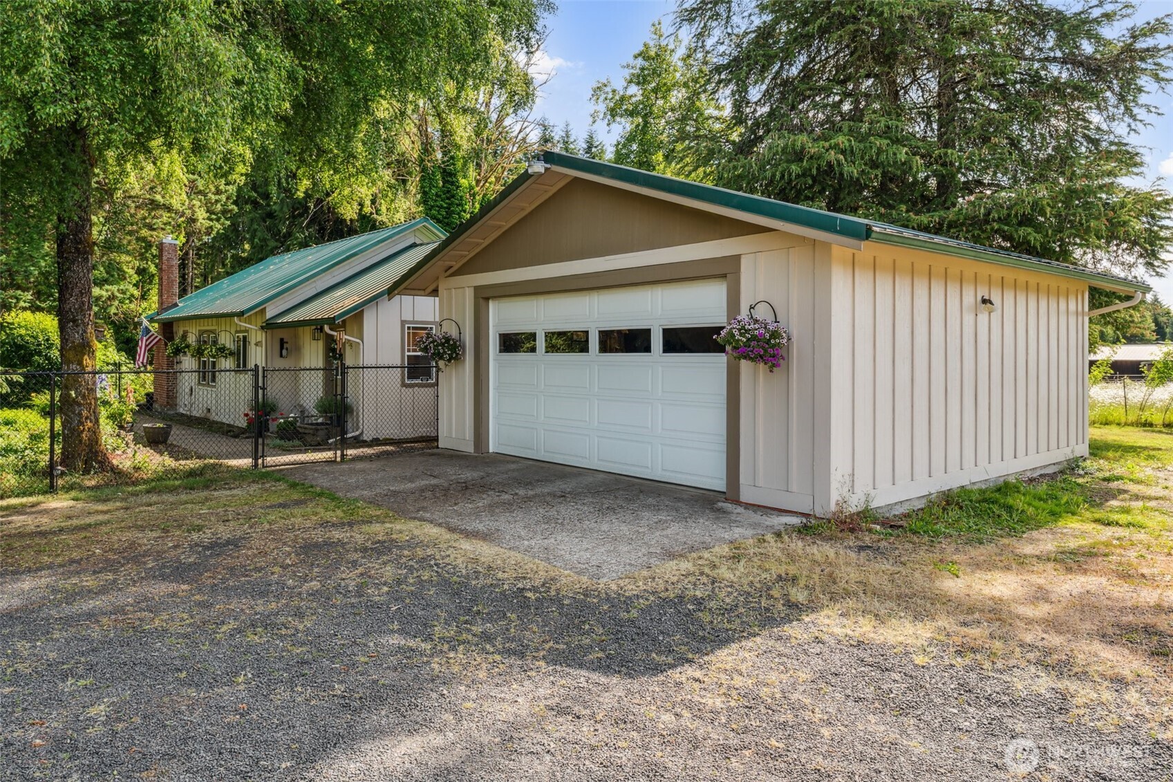 a view of a small house next to a yard with large tree