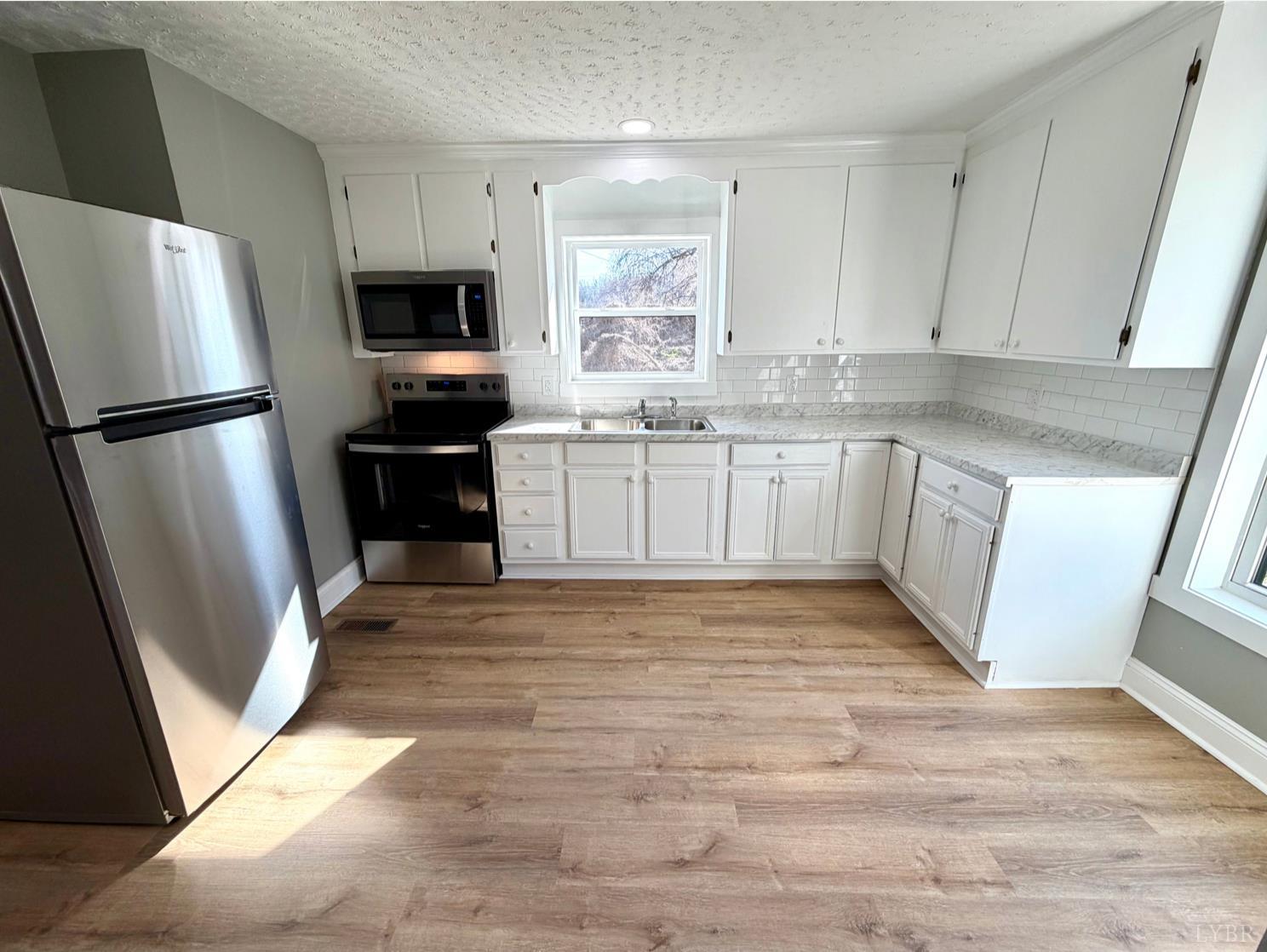 117 Monroe Street Monroe, VA 24574 - Photo 12 of 37 a kitchen with granite countertop a refrigerator sink and microwave