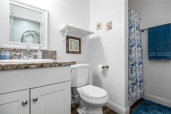 a bathroom with a granite countertop sink toilet and shower