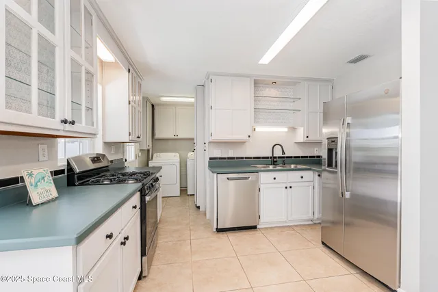 a kitchen with stainless steel appliances a refrigerator sink and cabinets