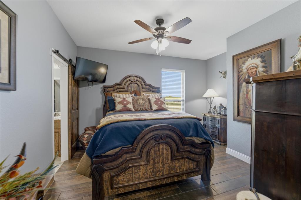 10106 Prather Road Springtown, TX 76082 - Photo 19 of 40 a bedroom with a bed and wooden floor