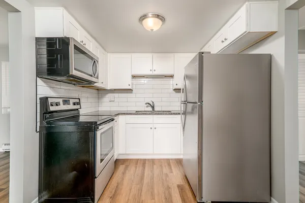 a kitchen with stainless steel appliances a refrigerator sink and microwave