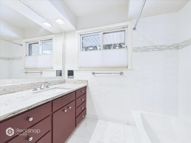 a spacious bathroom with a granite countertop sink mirror and double