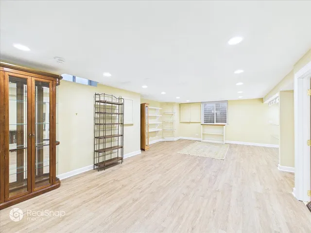 a view of an empty room with wooden floor and windows