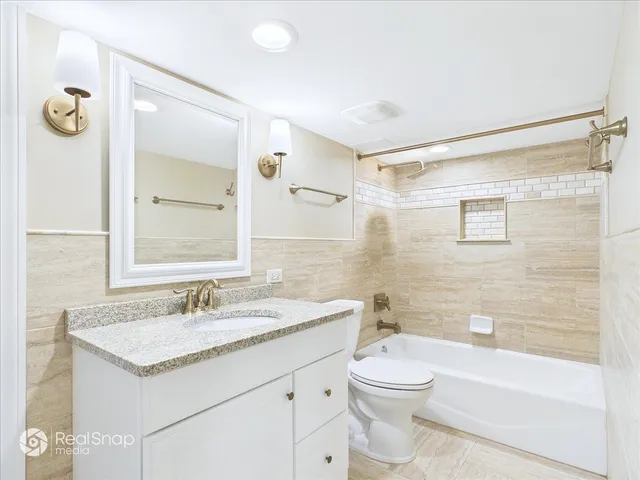 a bathroom with a granite countertop sink a toilet and shower