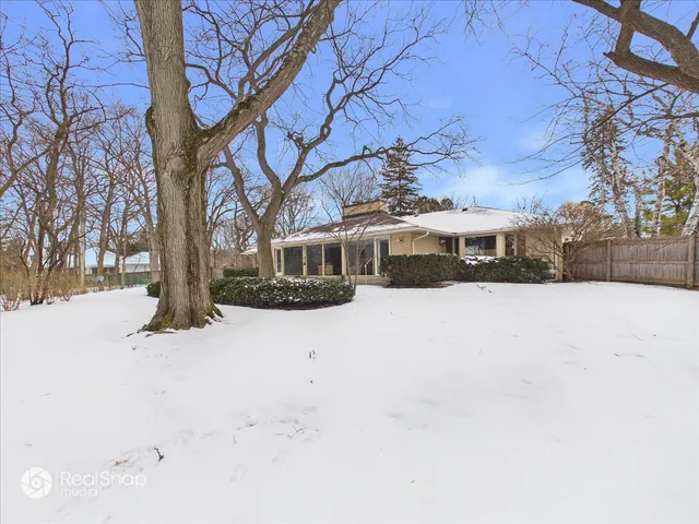 a front view of a house with a yard covered in snow