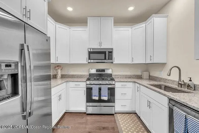 a kitchen with stainless steel appliances granite countertop a stove a sink and a refrigerator