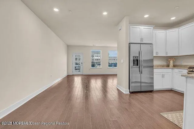 a view of kitchen with stainless steel appliances a refrigerator and wooden floor