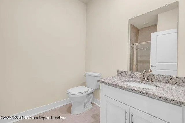 a bathroom with a granite countertop toilet and a sink