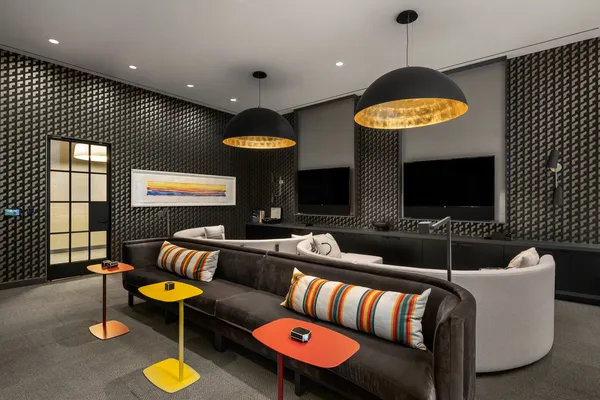 an outdoor living room with furniture and a flat screen tv