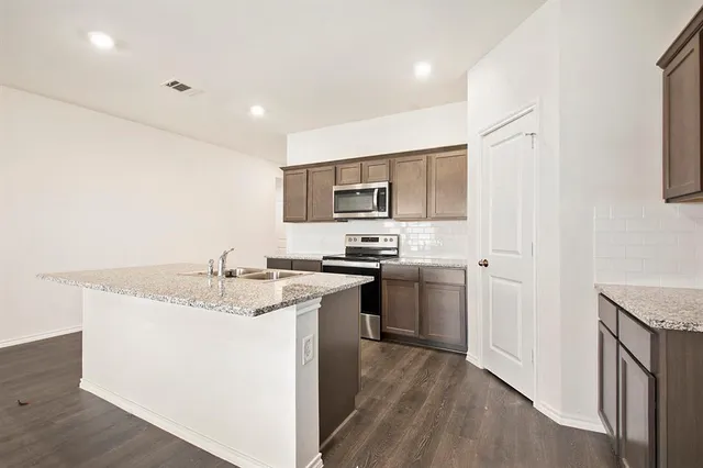 a kitchen with a sink stove and refrigerator