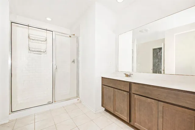 a bathroom with a shower sink and mirror