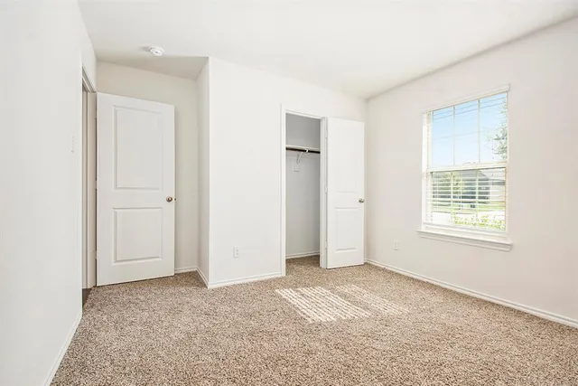 an empty room with windows and closet