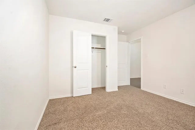 an empty room with closet and windows