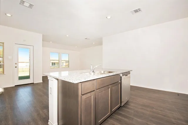 a kitchen with a sink and wooden floor