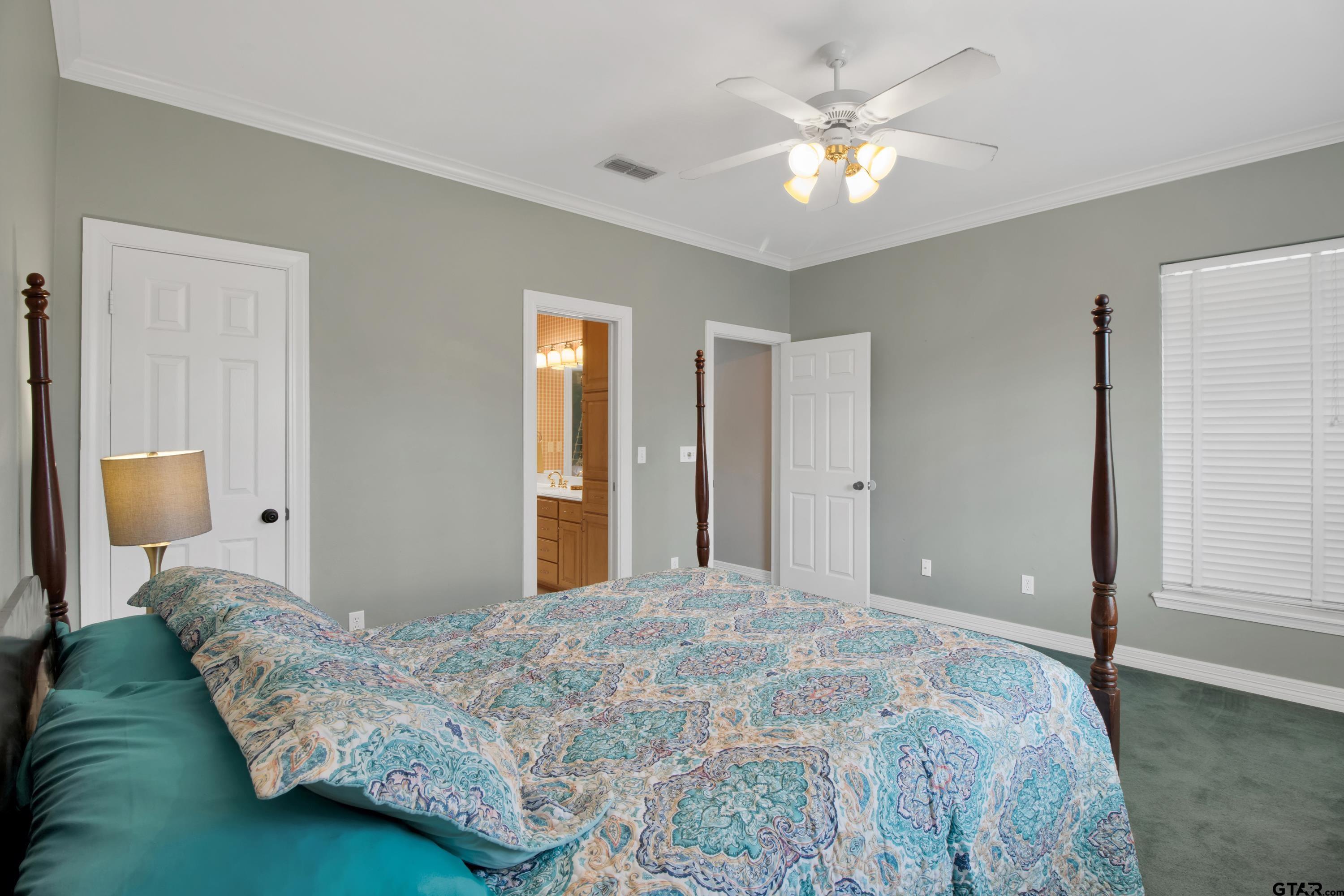 3800 Holly Ridge Drive Longview, TX 75605 - Photo 19 of 38 a bedroom with a bed and a chandelier