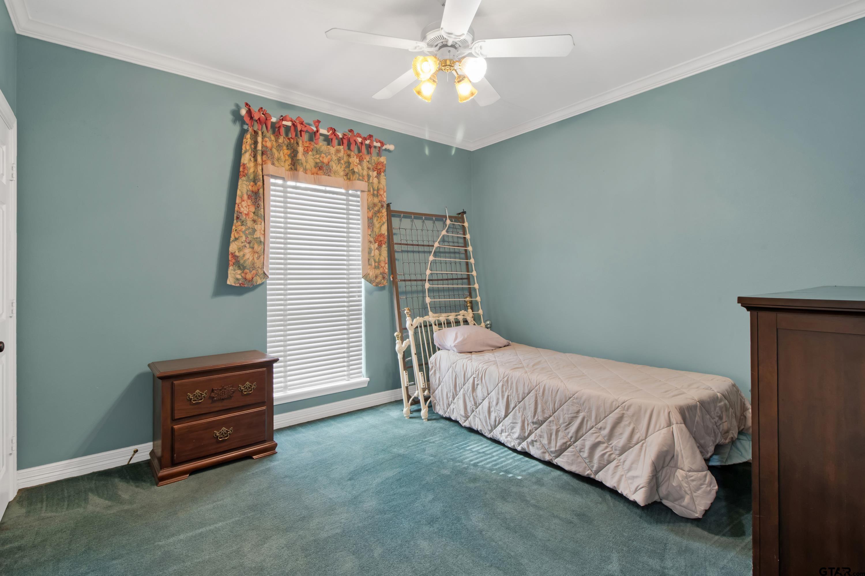 3800 Holly Ridge Drive Longview, TX 75605 - Photo 22 of 38 a bedroom with a bed and a chandelier