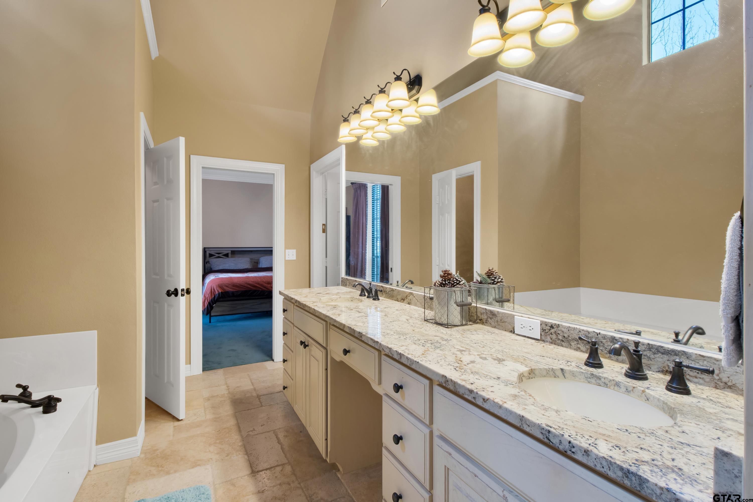 3800 Holly Ridge Drive Longview, TX 75605 - Photo 26 of 38 a spacious bathroom with a granite countertop double vanity sink a mirror and a shower