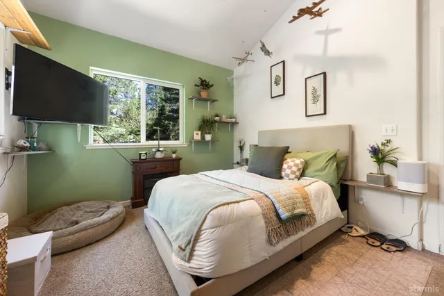 a bedroom with a bed window and a flat screen tv