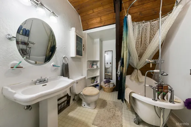 a bathroom with a toilet sink and mirror