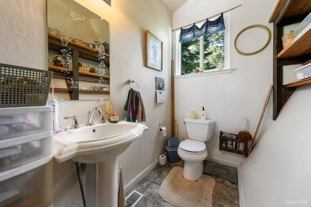 a bathroom with a sink a toilet and a mirror