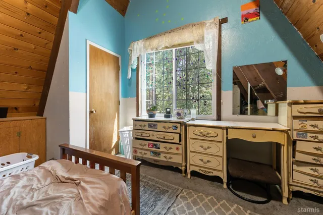 a bedroom with a bed a book shelf and a book shelf