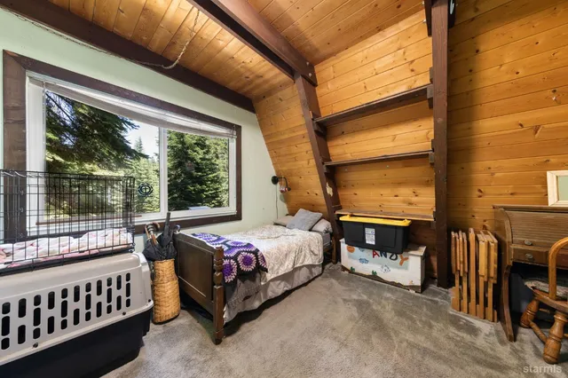 a view of an empty room with a window and furniture