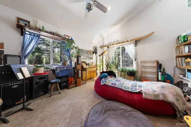 a bedroom with bed and a flat tv screen on dresser