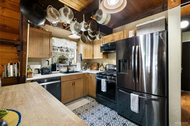 a kitchen with stainless steel appliances granite countertop a refrigerator a stove top oven a sink and dishwasher