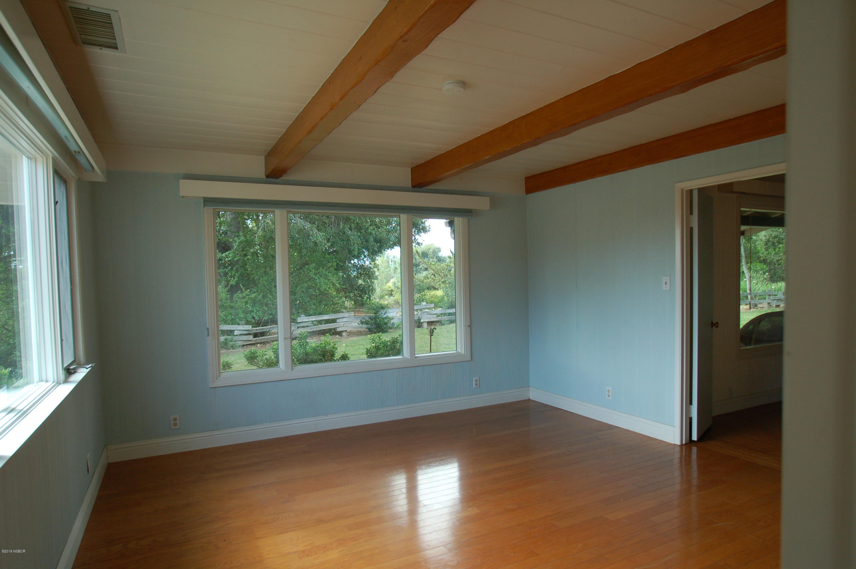 724 North Refugio Road Santa Ynez, CA 93460 - Photo 13 of 25 an empty room with wooden floor and windows