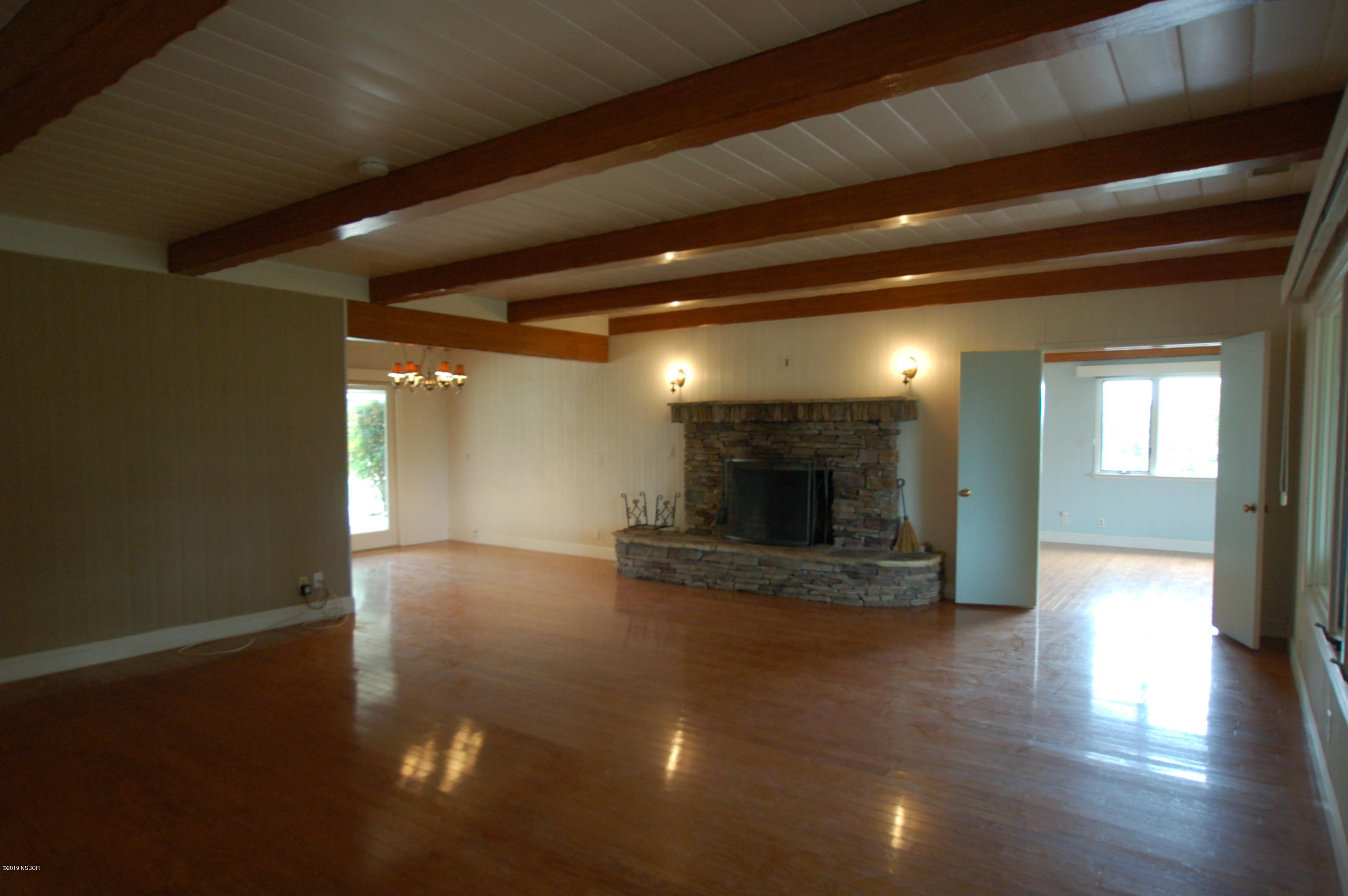 724 North Refugio Road Santa Ynez, CA 93460 - Photo 5 of 25 a view of a hallway with wooden floor and a fireplace