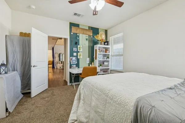 a bedroom with a large bed and a chandelier