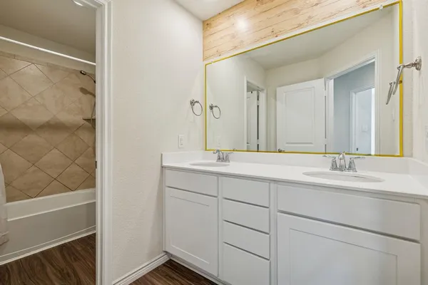 a bathroom with a double vanity sink mirror and shower