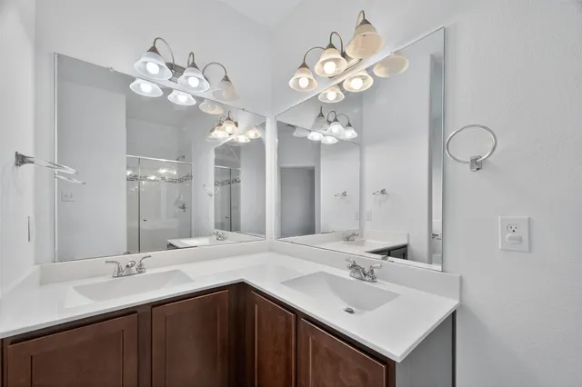 a bathroom with a sink vanity a mirror and a shower