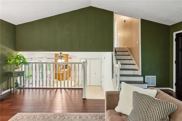 a view of a hallway with furniture and wooden floor