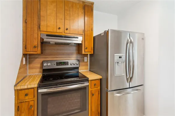 a kitchen with stainless steel appliances granite countertop a refrigerator and a stove