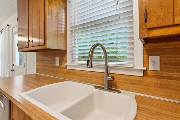 a view of a kitchen with kitchen island a sink and a large window