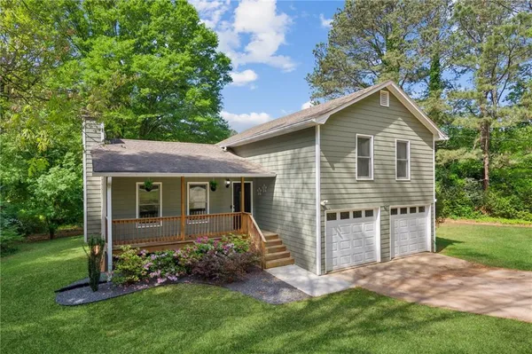 a front view of a house with a garden and yard