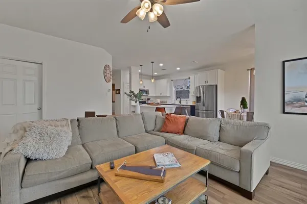 a living room with furniture and a view of kitchen