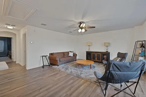 a living room with furniture a chandelier and a window