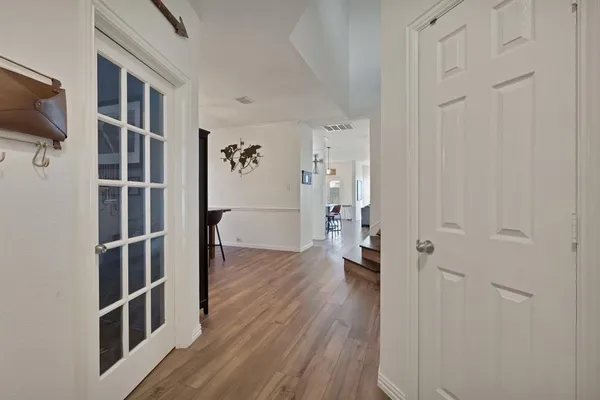 a view of a hallway with wooden floor and staircase