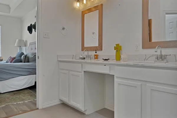 a bathroom with a sink double vanity granite tub shower and a mirror