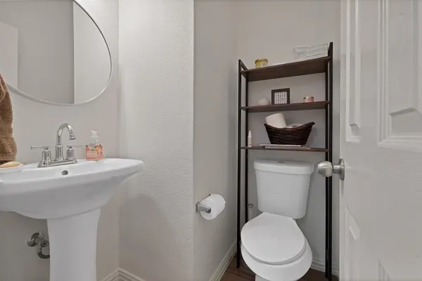 a en suite bathroom with a granite countertop sink a toilet and a mirror