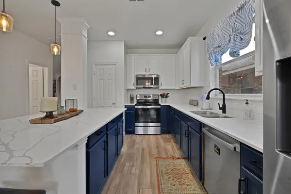 a kitchen with stainless steel appliances granite countertop a sink stove and cabinets