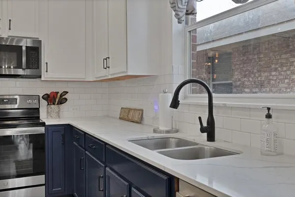 a kitchen with kitchen island granite countertop a refrigerator and a stove top oven
