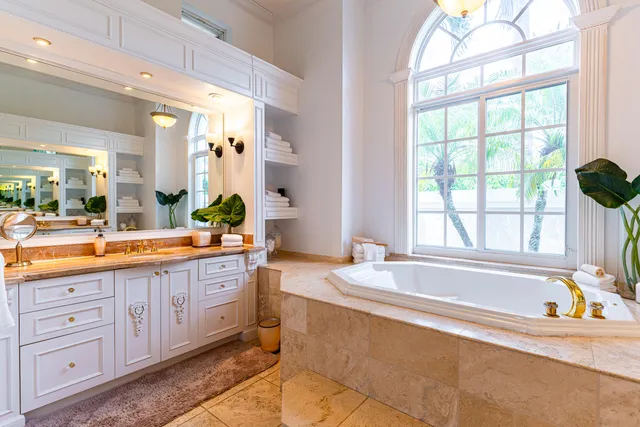 a spacious bathroom with a granite countertop tub sink and mirror