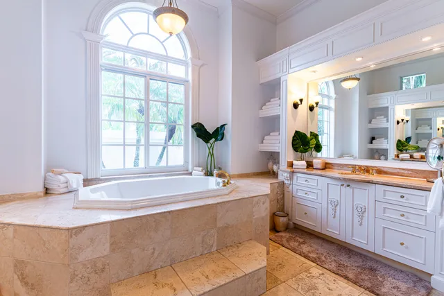 a spacious bathroom with a tub sink and mirror