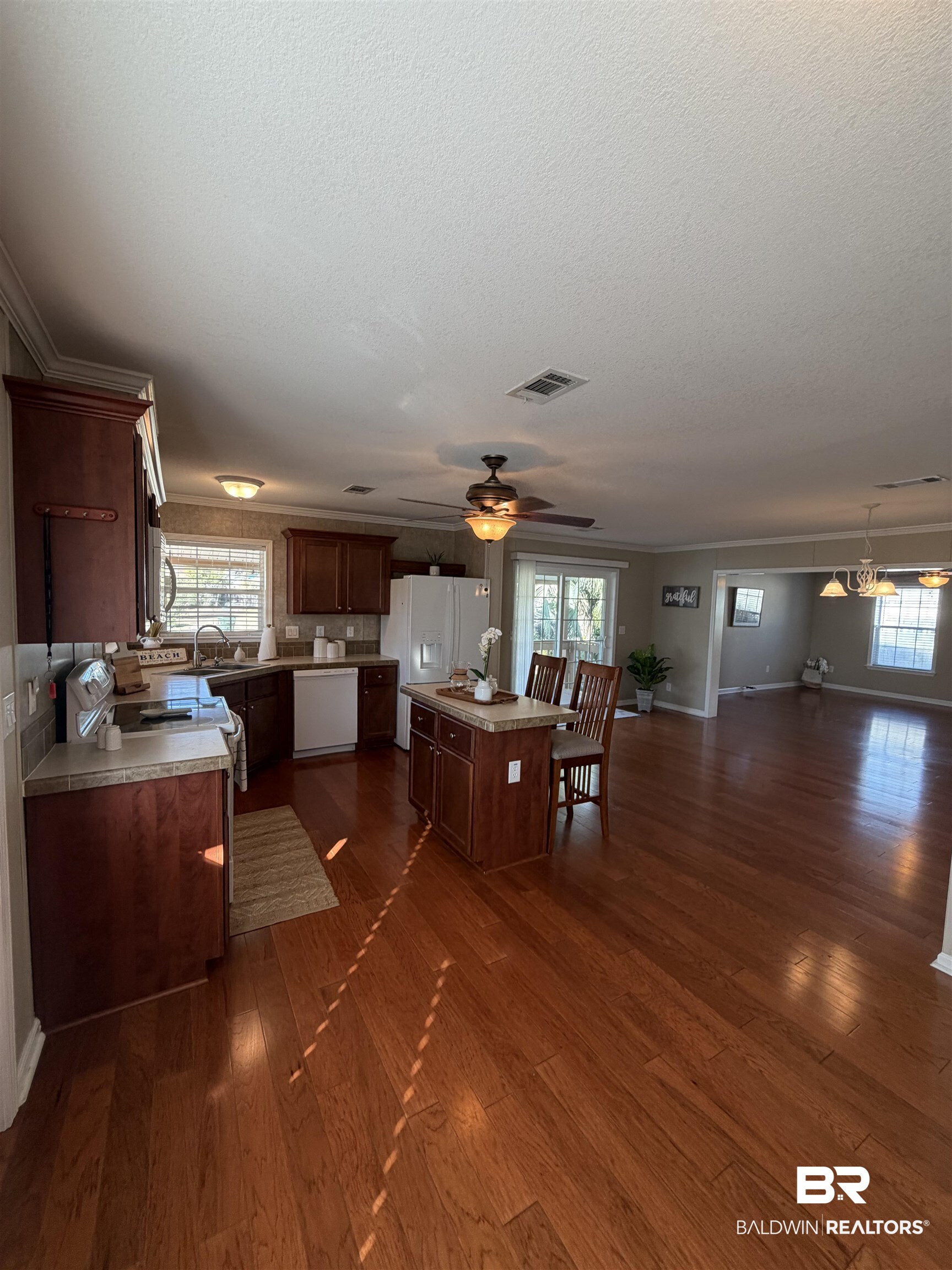 675 Escambia Loop Lillian, AL 36549 - Photo 43 of 44 Kitchen with a kitchen island, dark brown cabinetry, light countertops, open floor plan, and a textured ceiling