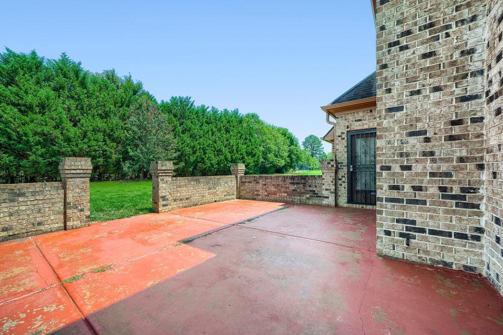 345 Masters Club Boulevard Hampton, GA 30228 - Photo 27 of 30 a view of a backyard with brick wall and potted plants