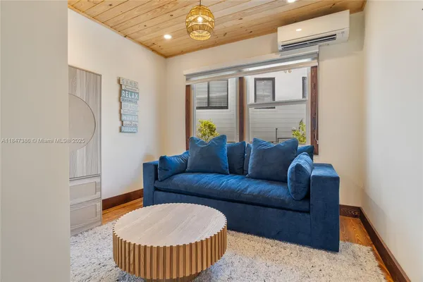 a bedroom with a bed a tv and wooden floor